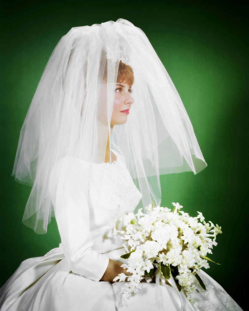 1960s-bride-portrait-seated-white-wedding-gown-bridal-news-photo-1584039436